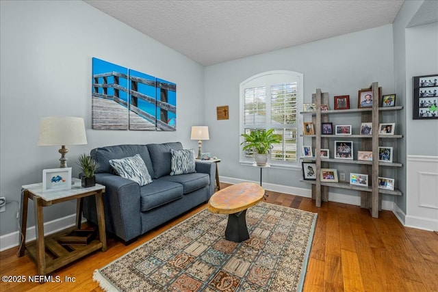 living area with hardwood / wood-style floors and a textured ceiling