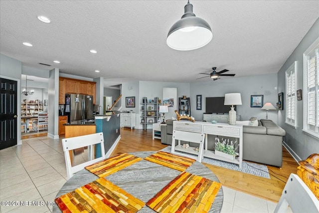 tiled living room with ceiling fan and a textured ceiling