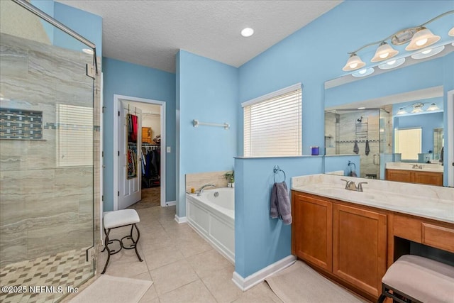 bathroom with vanity, separate shower and tub, tile patterned flooring, and a textured ceiling