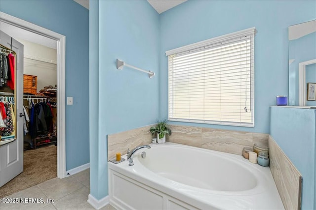 bathroom with tile patterned flooring and a tub to relax in