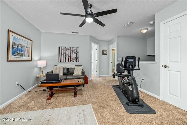 exercise room with ceiling fan, carpet floors, and a textured ceiling