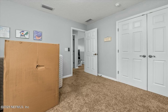 unfurnished bedroom featuring a closet, carpet flooring, and a textured ceiling