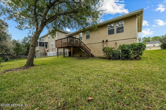 rear view of house with a wooden deck and a yard