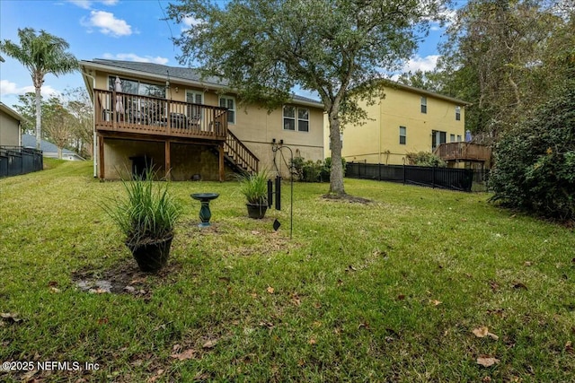 rear view of property featuring a wooden deck and a yard