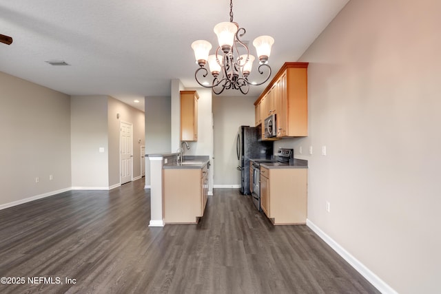 kitchen featuring sink, dark wood-type flooring, stainless steel appliances, light brown cabinetry, and decorative light fixtures