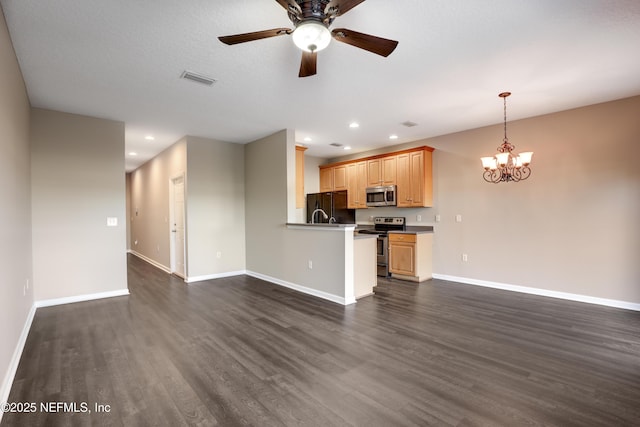 kitchen featuring ceiling fan with notable chandelier, light brown cabinetry, kitchen peninsula, stainless steel appliances, and dark wood-type flooring