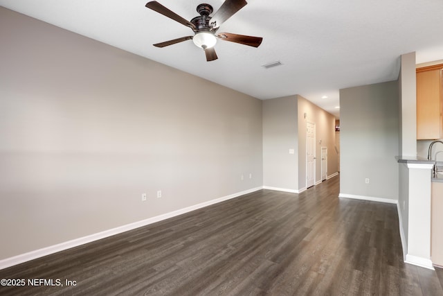 unfurnished living room with dark wood-type flooring and ceiling fan