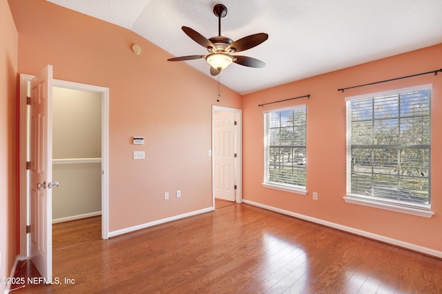 unfurnished bedroom featuring lofted ceiling, hardwood / wood-style flooring, and ceiling fan