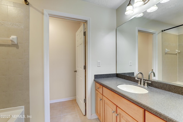 bathroom with tiled shower, vanity, tile patterned flooring, and a textured ceiling