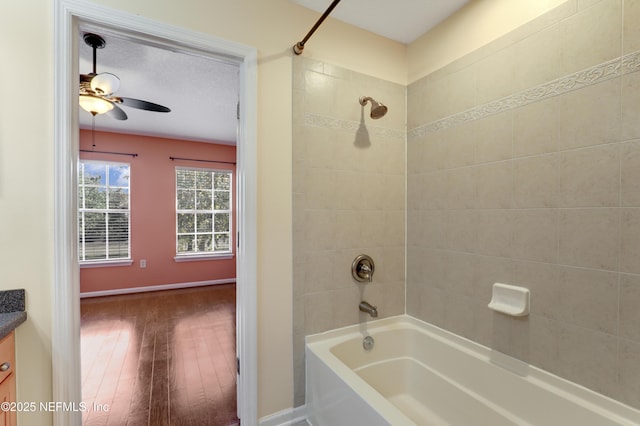 bathroom featuring tiled shower / bath combo, vanity, wood-type flooring, and ceiling fan