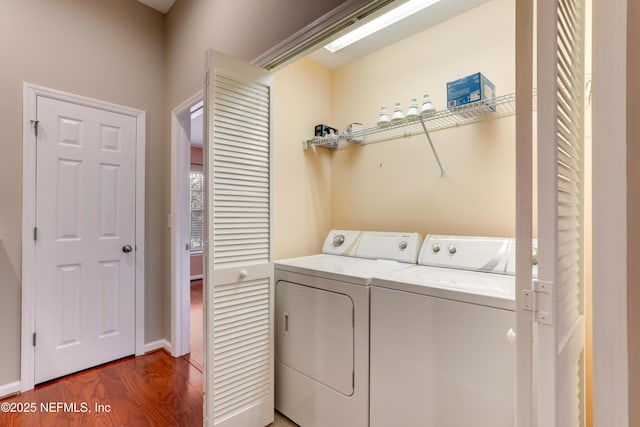 laundry room with hardwood / wood-style floors and washer and dryer