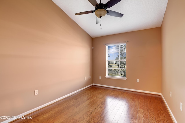 spare room featuring lofted ceiling, a textured ceiling, ceiling fan, and light wood-type flooring