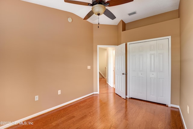 unfurnished bedroom with vaulted ceiling, ceiling fan, light hardwood / wood-style floors, and a closet