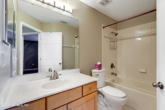 full bathroom featuring vanity, toilet, tiled shower / bath combo, and a textured ceiling