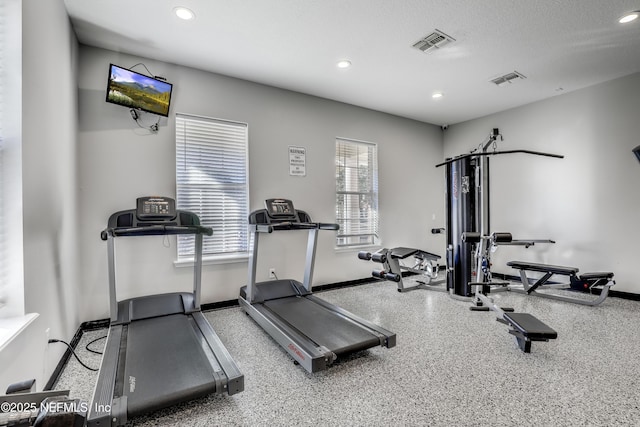 exercise room featuring plenty of natural light and a textured ceiling