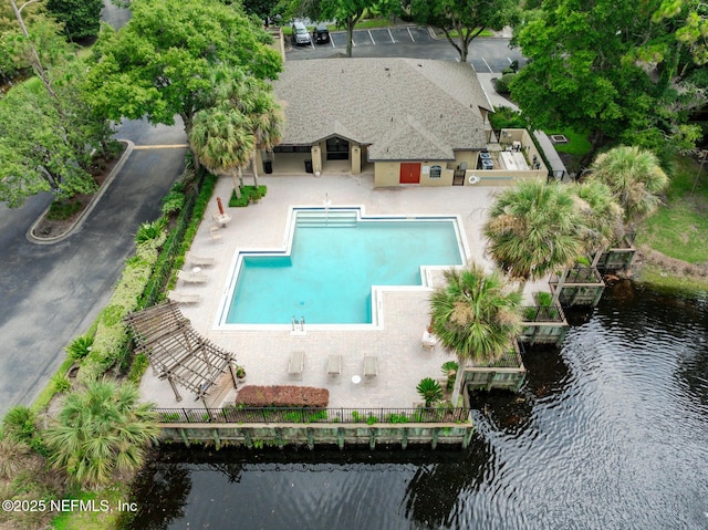 view of swimming pool featuring a water view and a patio