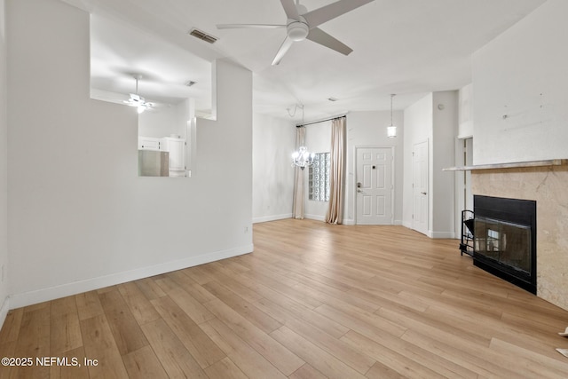 unfurnished living room featuring ceiling fan, a fireplace, and light hardwood / wood-style floors