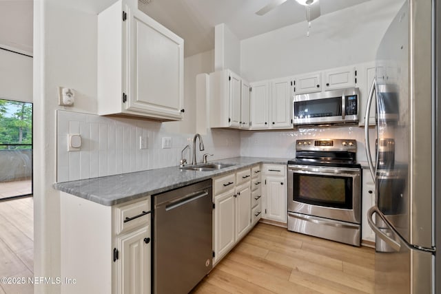 kitchen with white cabinetry, appliances with stainless steel finishes, sink, and decorative backsplash