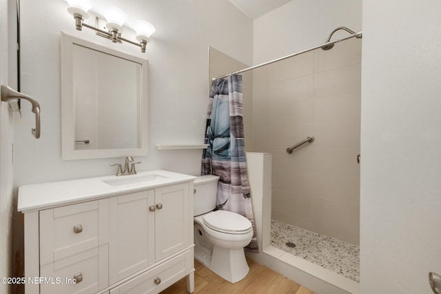 bathroom featuring hardwood / wood-style flooring, vanity, curtained shower, and toilet