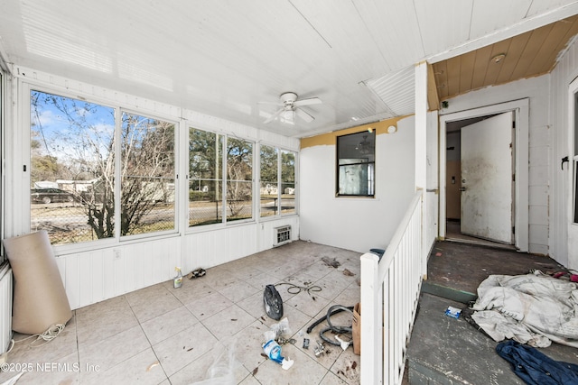 unfurnished sunroom featuring heating unit and ceiling fan