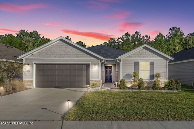 ranch-style house with a garage and a lawn