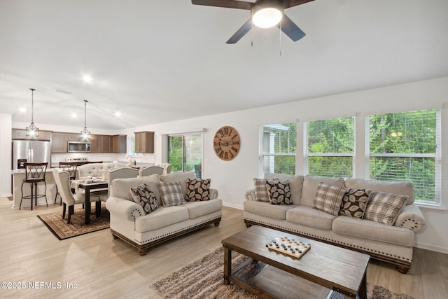 living room with lofted ceiling, light hardwood / wood-style flooring, and ceiling fan