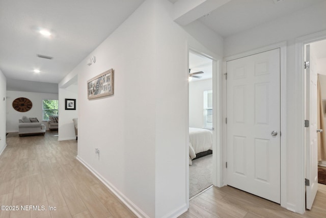 hallway with light hardwood / wood-style floors