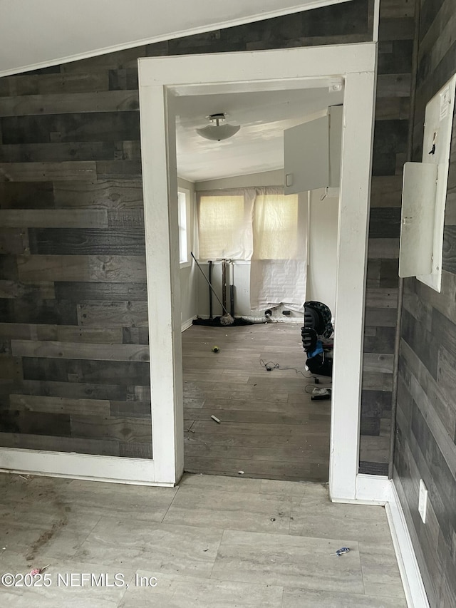 corridor featuring light hardwood / wood-style flooring and wood walls