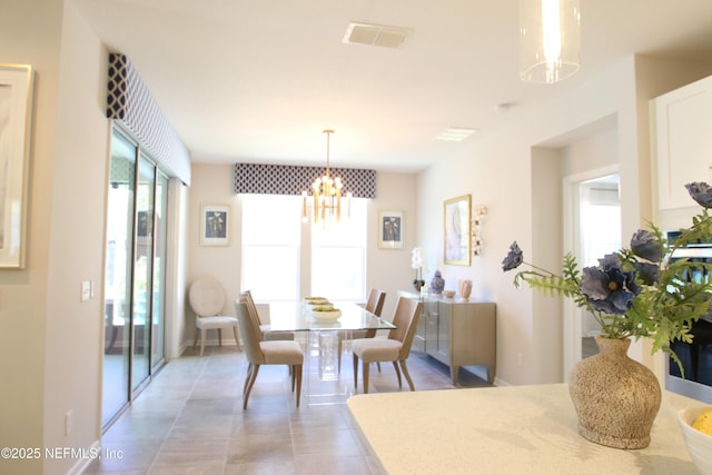 tiled dining room featuring a chandelier