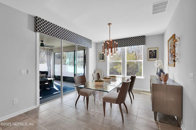 dining space featuring ceiling fan with notable chandelier and tile patterned flooring