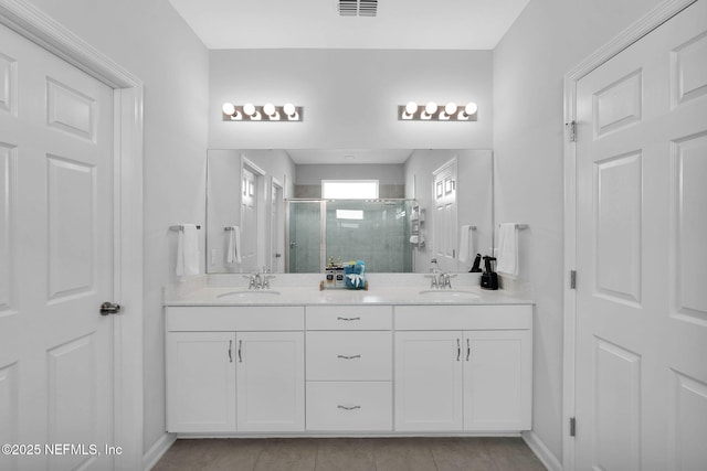 bathroom featuring vanity, tile patterned flooring, and walk in shower