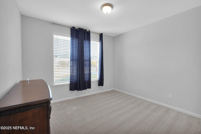 spare room featuring light colored carpet