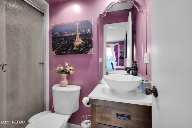 bathroom with vanity, a shower with door, and toilet