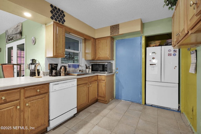 kitchen featuring white appliances and a textured ceiling