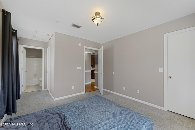 bedroom with connected bathroom and carpet flooring