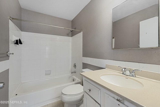 full bathroom with tiled shower / bath, vanity, and toilet