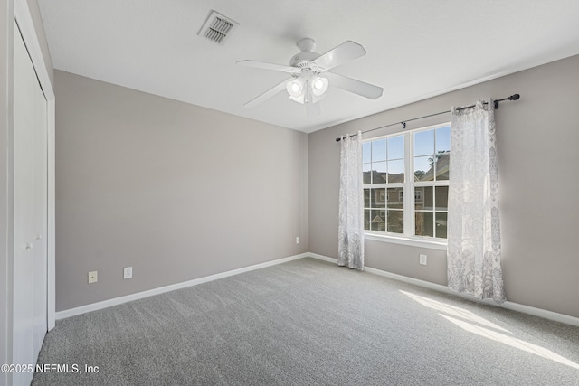 carpeted spare room featuring ceiling fan