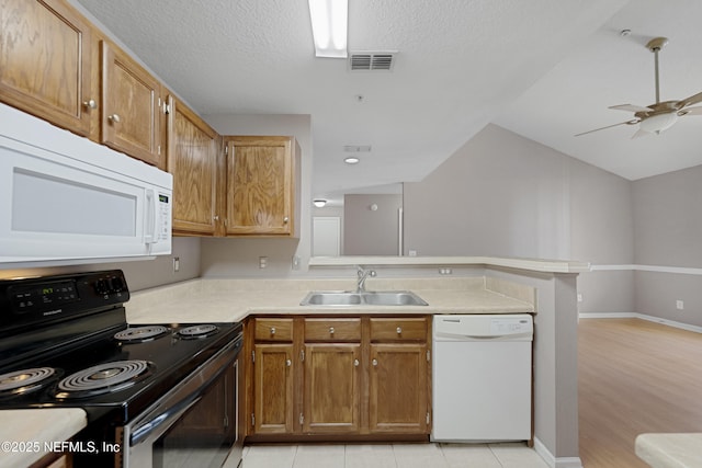 kitchen featuring sink, white appliances, ceiling fan, a textured ceiling, and kitchen peninsula