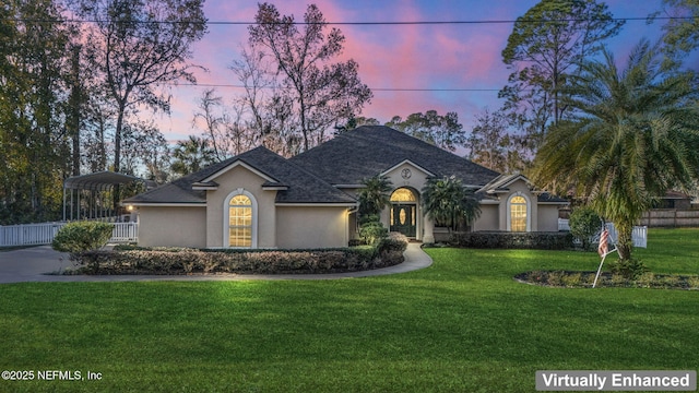 view of front of property with a carport and a lawn