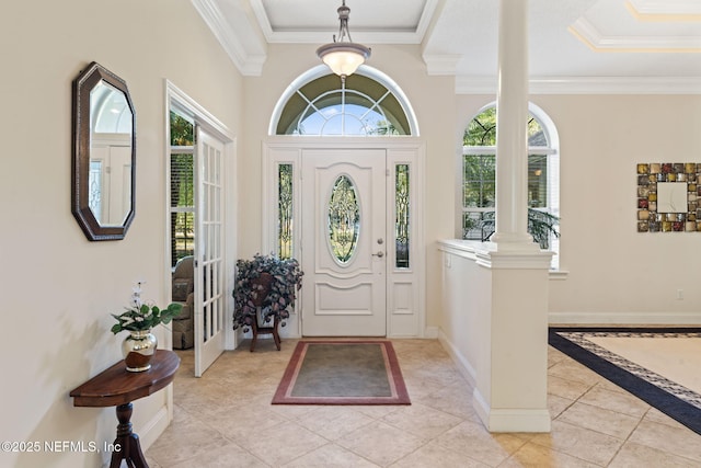 tiled foyer entrance featuring decorative columns, ornamental molding, and a wealth of natural light