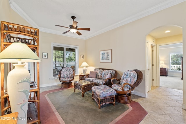 living room with light tile patterned flooring, ornamental molding, and ceiling fan