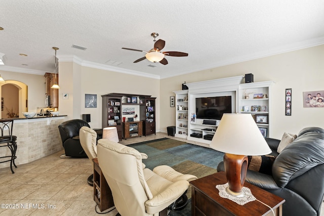 living room featuring crown molding, ceiling fan, a textured ceiling, and light tile patterned floors