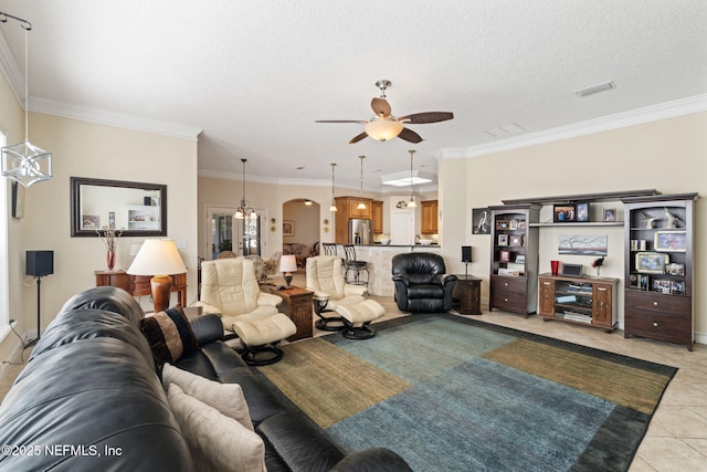 tiled living room with ceiling fan, ornamental molding, and a textured ceiling