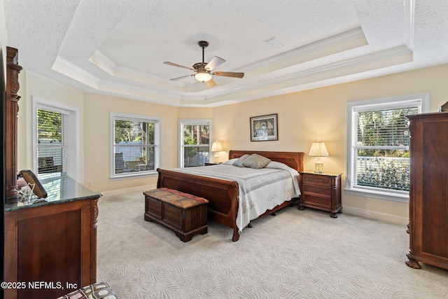 carpeted bedroom with crown molding, ceiling fan, a raised ceiling, and multiple windows