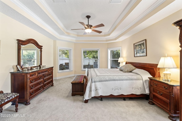 carpeted bedroom featuring multiple windows, crown molding, ceiling fan, and a tray ceiling