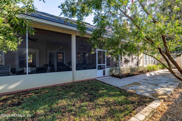 rear view of house with a patio area and a sunroom