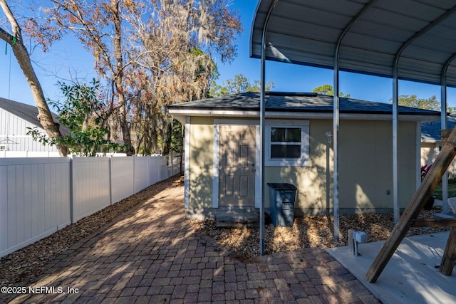 view of side of property featuring a patio and a storage unit