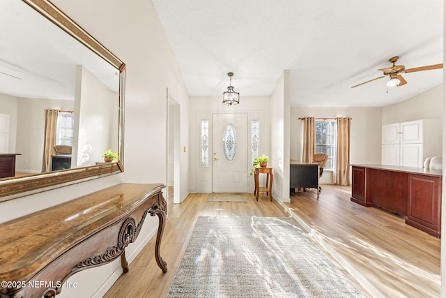 foyer entrance with plenty of natural light, ceiling fan, and light wood-type flooring