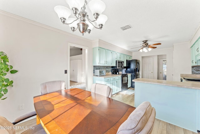 dining area featuring ceiling fan with notable chandelier, ornamental molding, and light wood-type flooring