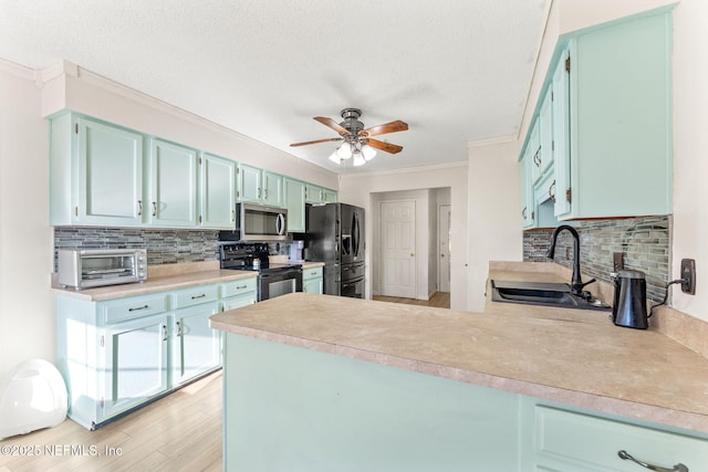 kitchen with kitchen peninsula, sink, ceiling fan, black appliances, and crown molding